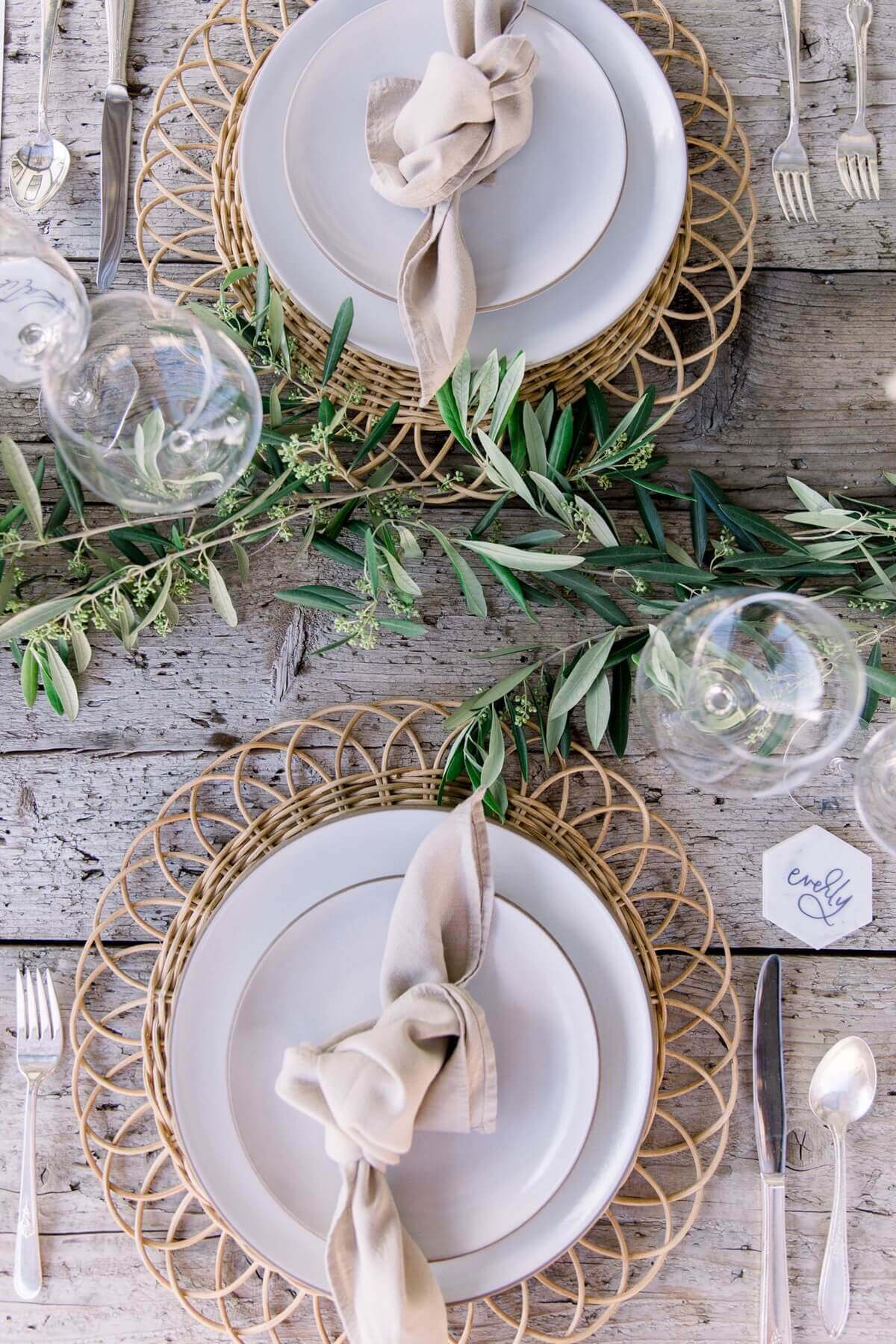 sustainable wedding welcome party table detaiplace setting with woven charger, knotted linen napkin, and seasonal greenery for a refined organic style.