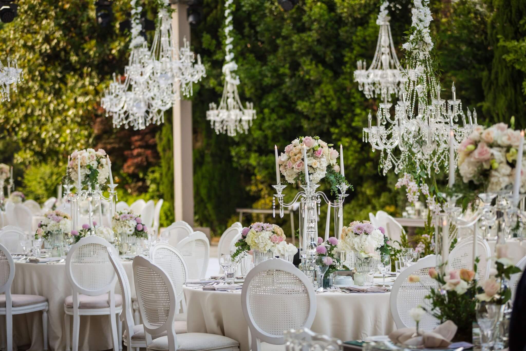 an elegant wedding reception outdoors with chandeliers