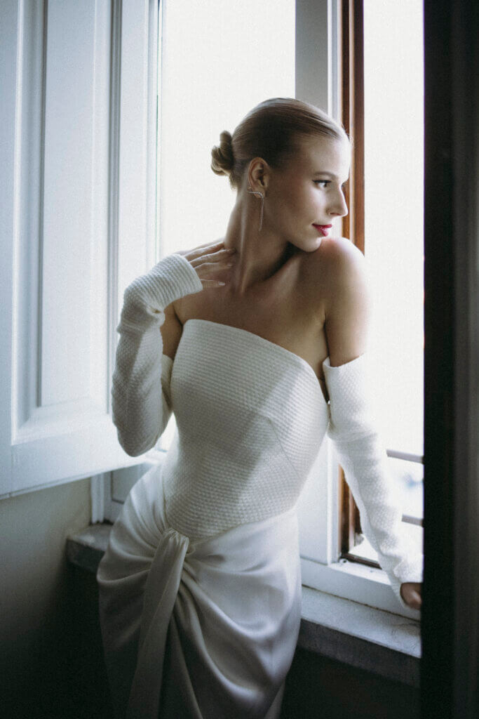serene bride not stressed looking outside in her wedding dress before her wedding