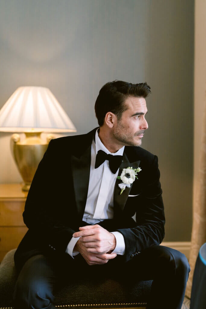 Old Hollywood wedding portrait at The Landmark London, with the groom in a black velvet tuxedo, framed by soft lighting .