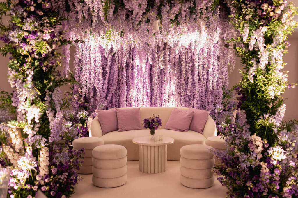 Lilac wisteria decor for Indian wedding Mehndi party stage with ivory lounge set planned by Roberta Burcheri Events
