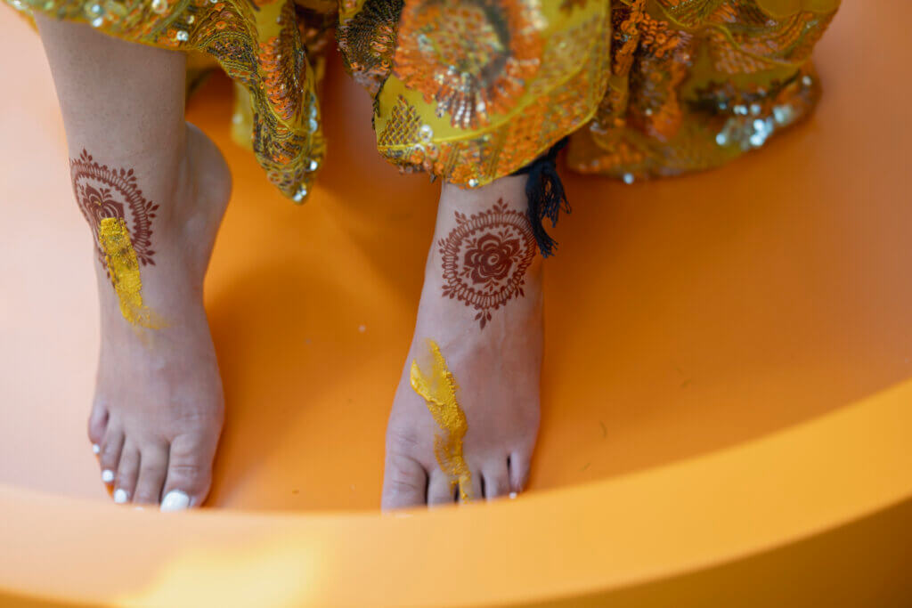 bride's henna-decorated feet during haldi ceremony
