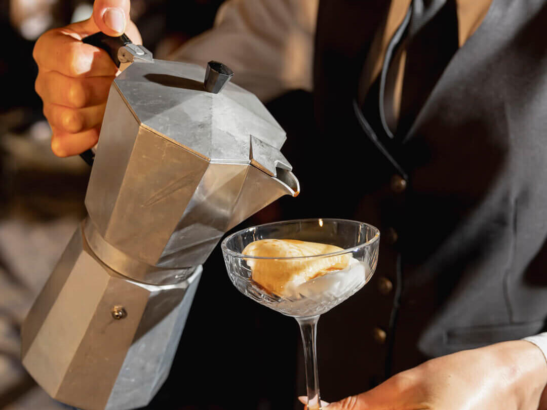 Affogato al caffè being poured into a coupe glass by uniformed server at a luxury wedding reception in Italy