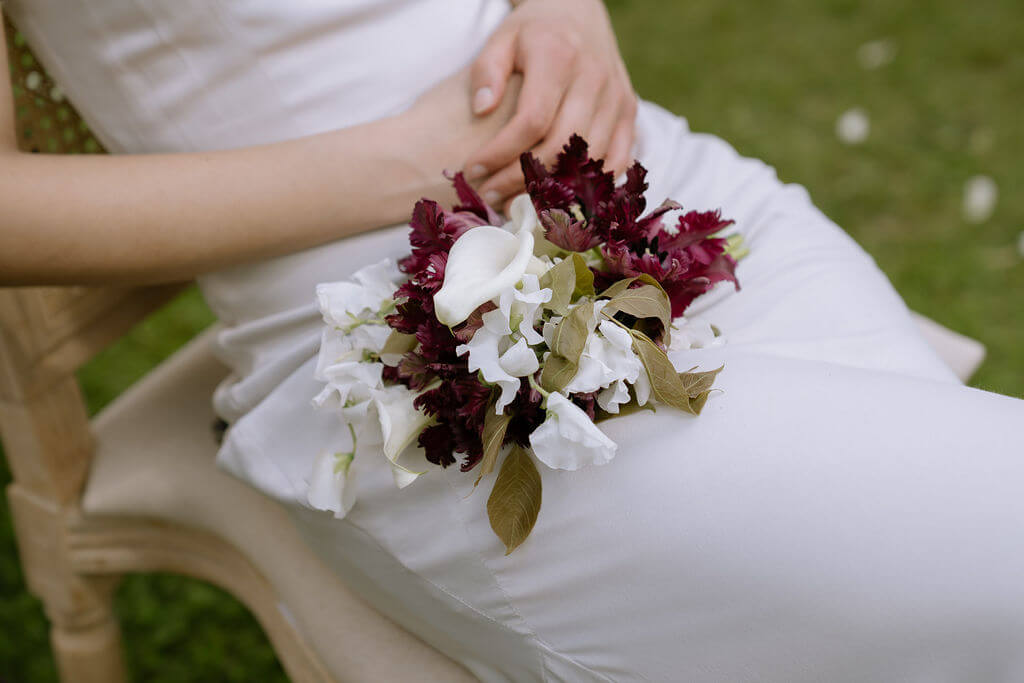 Bridesmaid holding a refined bouquet of seasonal eco-conscious flowers, designed in a luxurious natural style.